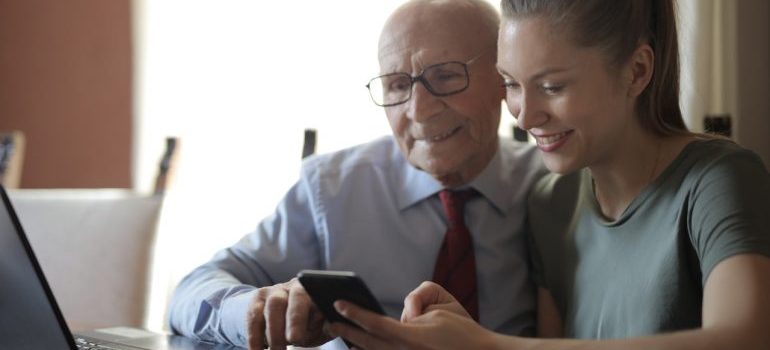 Daughter and father looking at the phone.