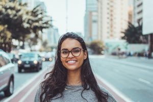 Happy woman thinking of costs of San Francisco vs. Miami