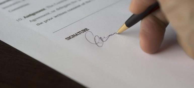 A person is signing the document