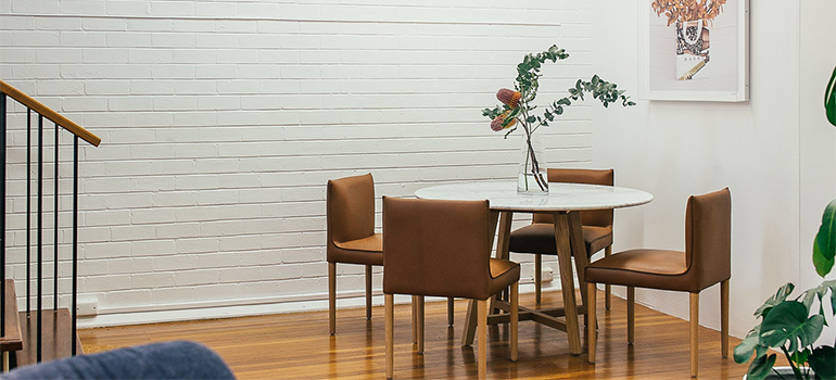 Table with a plant and chairs.