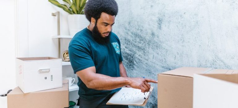 A professional mover checking on inventory boxes