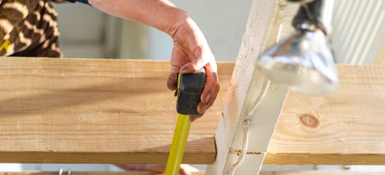 a man measuring the width of a wooden pole as the starting point to add value to your Boca Raton home