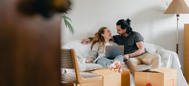 A couple organizing their mvoe and smiling