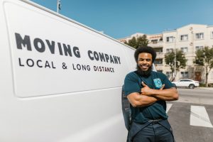 A mover posign in front of his van