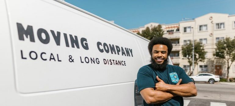 A mover posign in front of his van