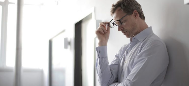 a man taking his glassess off while thinking about whether to invest in a rental in South Point or Hollywood