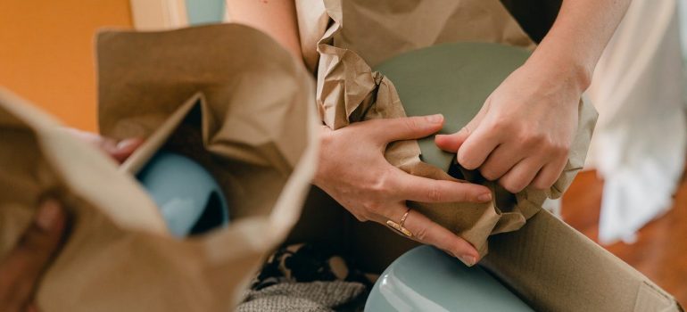 a couple packing fragile items into adequate packing supplies