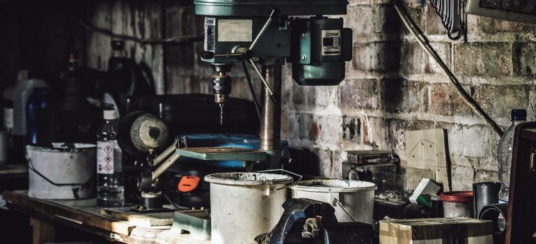 A working desk in a garage, full of tools.