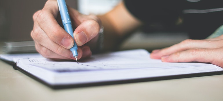 a person writing in the notebook