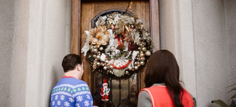 Couple standing in front of Christmas wreath