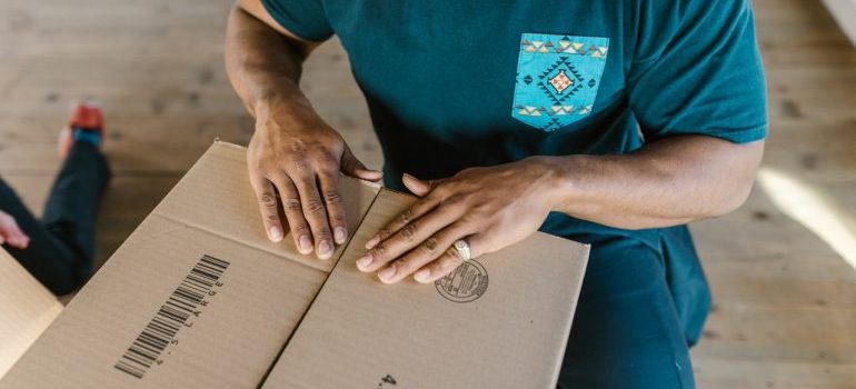 Person packing a box for a relocation to destinations for those who love warmer climate