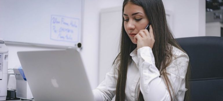 A woman on a call while she's looking at her computer