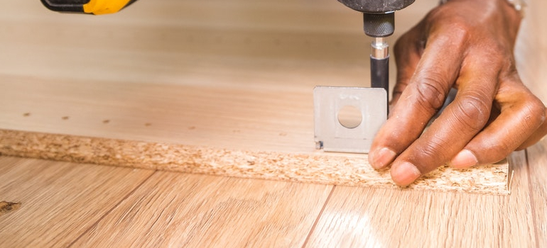 a person drilling a board