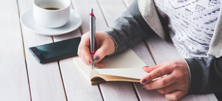 a woman writing in her notebook