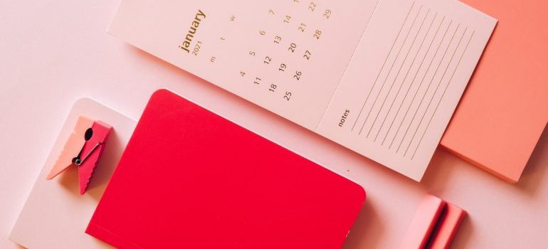 Calendar, notes, and pens on the table.