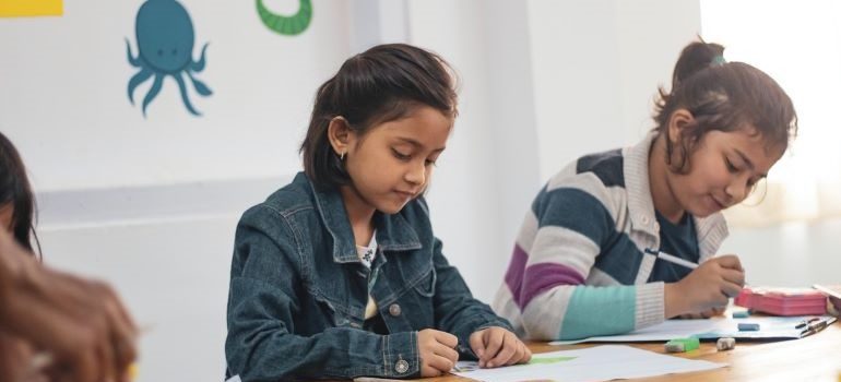 kid writing on paper about feeling of moving from Davie to South Point amid school year