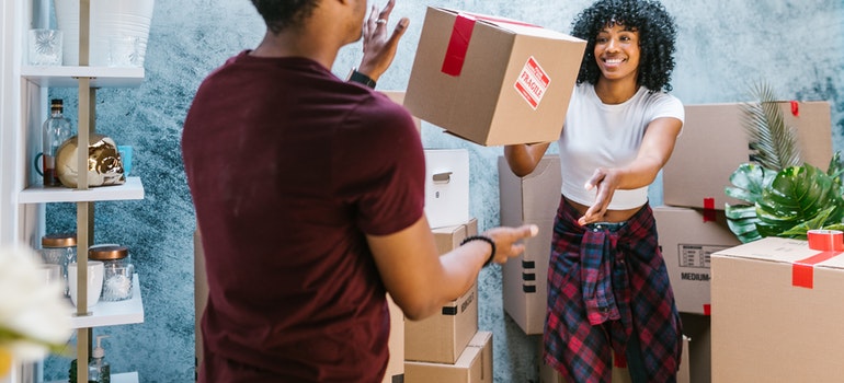 a couple having fun while packing for the move