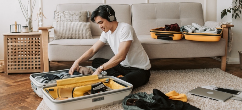 a man packing his suitcase before moving to one of the places in Florida for families with teenagers