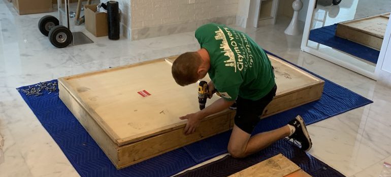 a mover packing an item in a crate