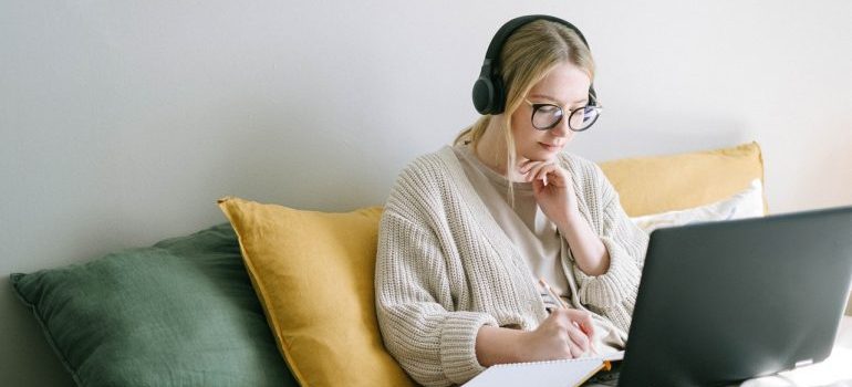 A girl working from home and taking notes in a notepad