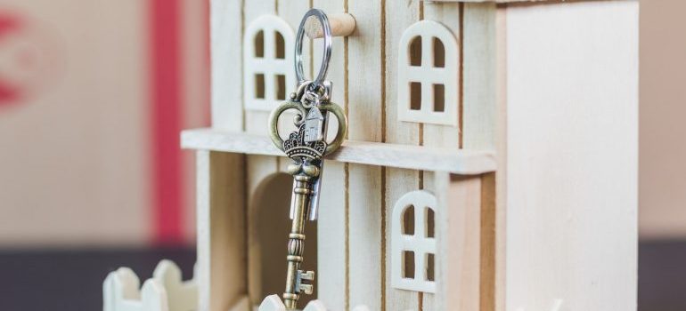 A key hanging from a small wooden house