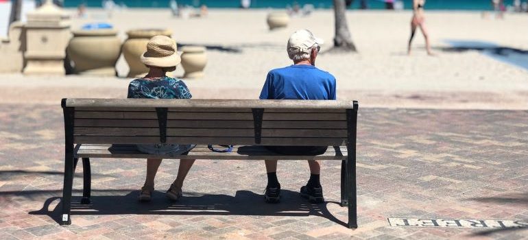 couple sitting on bench in one of the Best places to live in Miami area