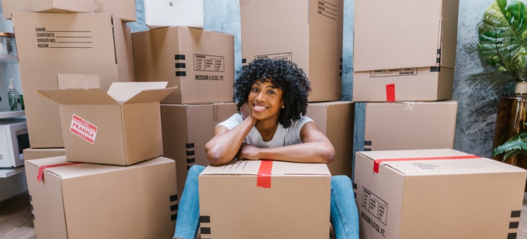 A happy woman with cardboard boxes.