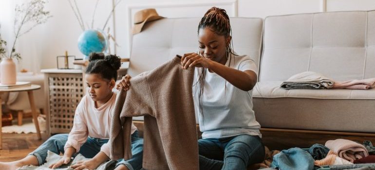 a woman and a girl packing clothes