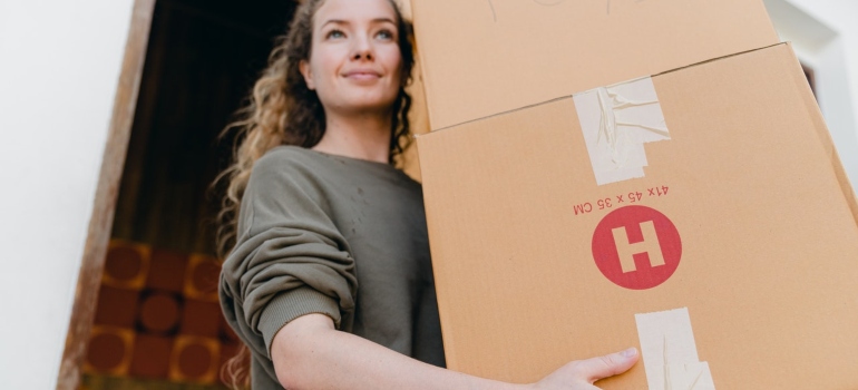 A woman carrying a moving box