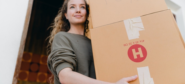 A woman carrying a moving box 