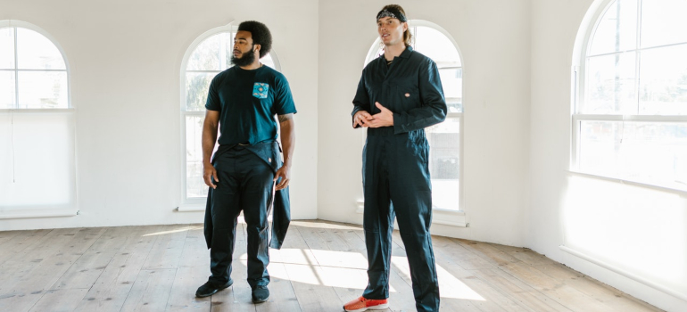 two moving crew personnel standing in an empty home