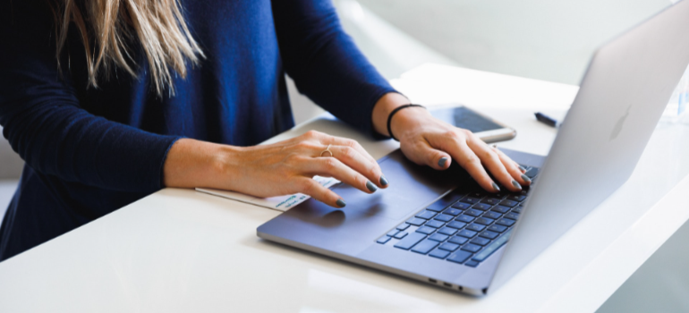 a woman reading on a laptop about Miami Beach vs. Fort Lauderdale