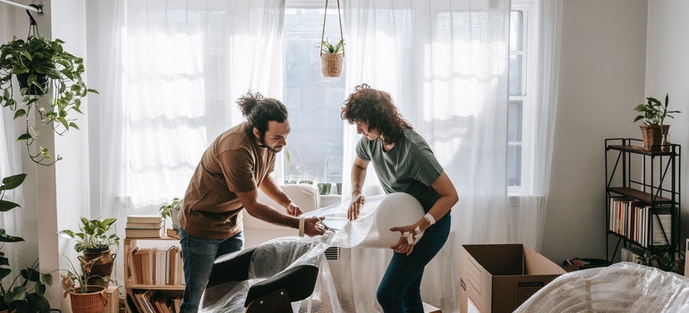 A woman and a man packing furniture for their Plantation move