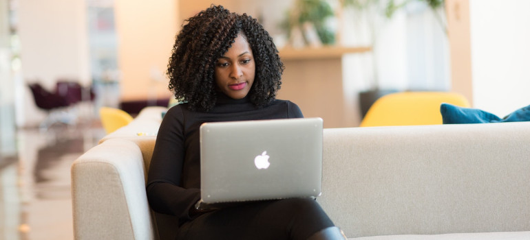 Woman using a laptop to make a timeline before moving her business to a smaller office in Boca Raton