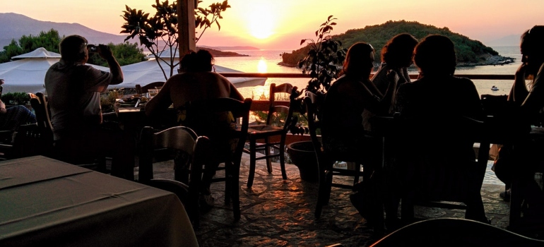 A group of friends sitting in a restaurant by the beach