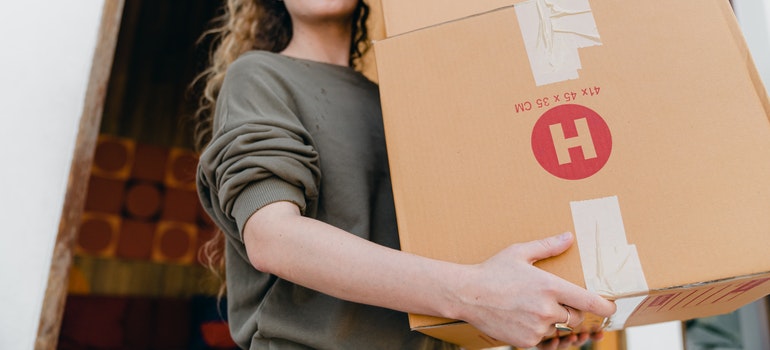 A woman carrying two boxes