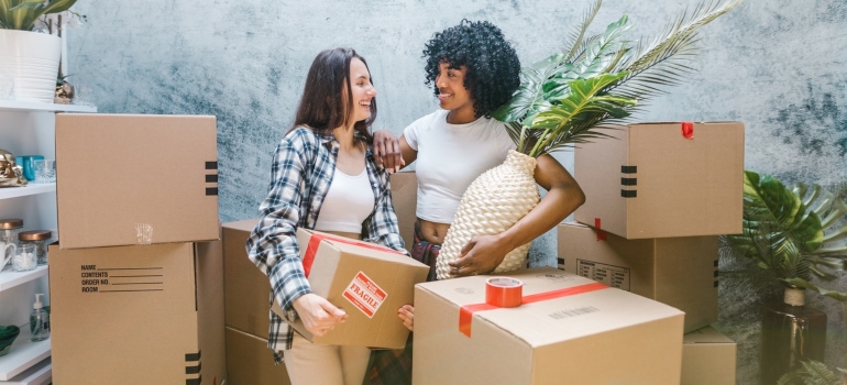 Two women smiling while relocating