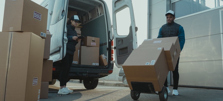 Two Florida movers putting moving boxes in a moving van