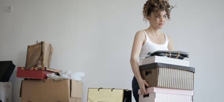 A woman collecting things to pack before your movers arrive