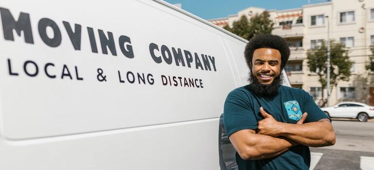 A mover standing in front of his van