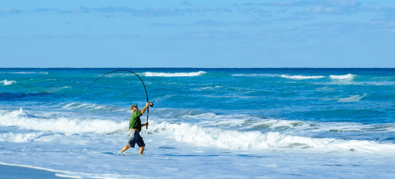 a man holding a fishing rod in the sea