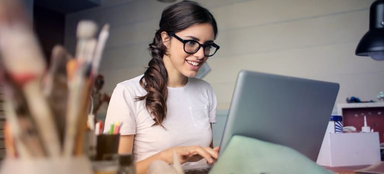 Woman using laptop and smiling