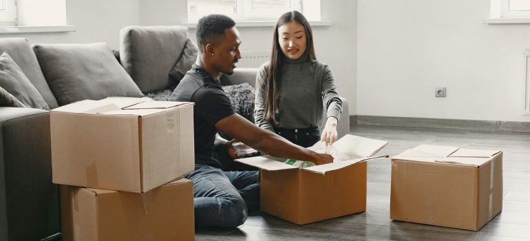 two people putting things into moving boxes