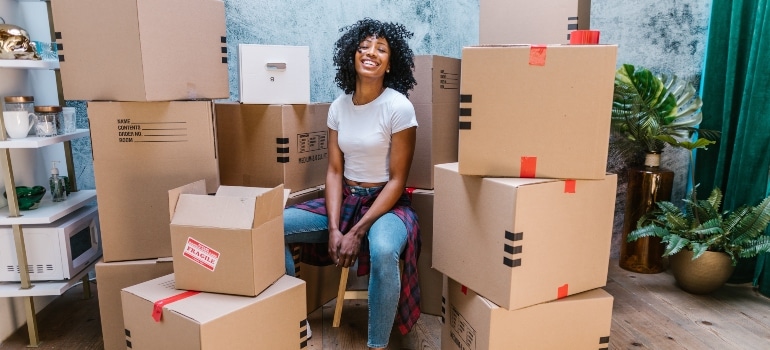 happy woman surrounded by moving boxes