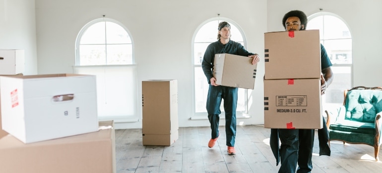 two guys carrying boxes and talking about moving to Boca Raton vs Miami