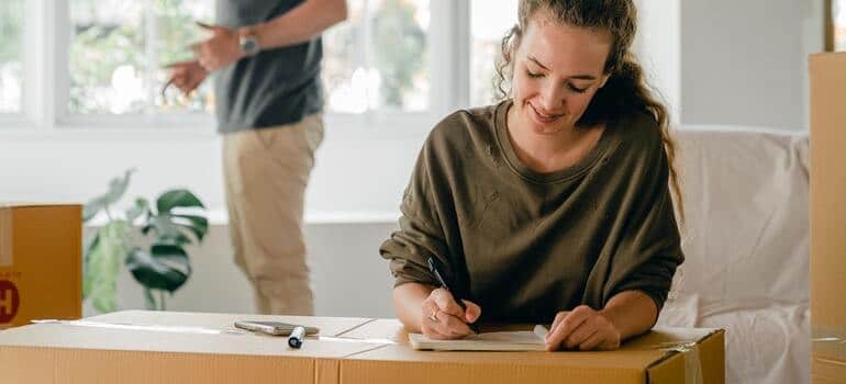 A woman making a budget while her partner packs