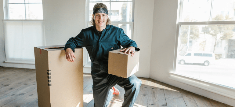 a man kneeling next to the moving box