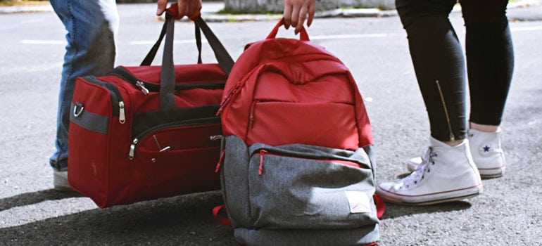 Two persons carrying bags