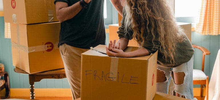 Two people packing boxes