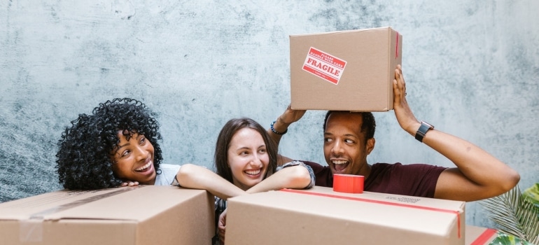 three people playing with boxes